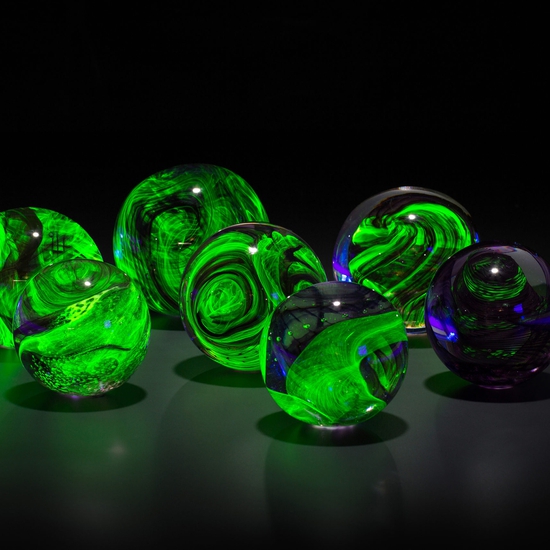 An installation view of Leaving a Legacy, a collection of uranium glass orbs