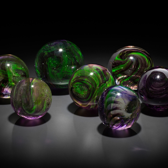 An installation view of Leaving a Legacy, a collection of uranium glass orbs